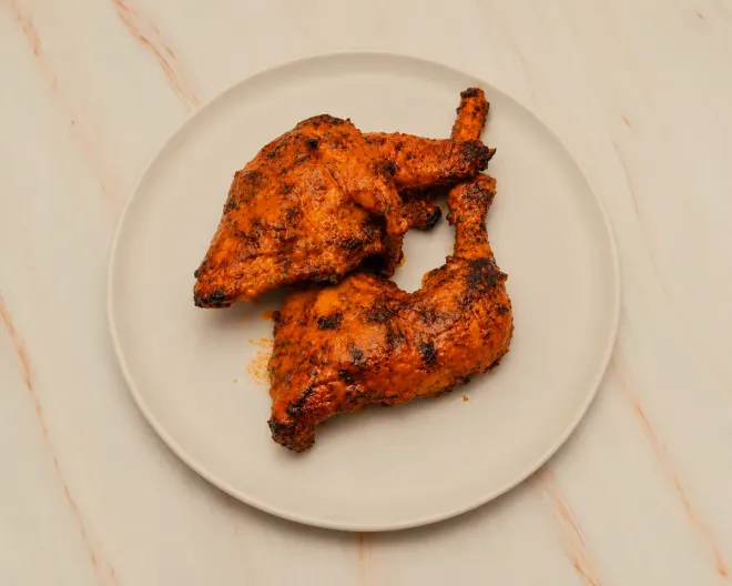 Half a peri peri chicken, flame-grilled and charred along the edges